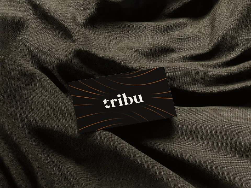 Tribu: Black business card with the tribu wordmark, on dark fabric